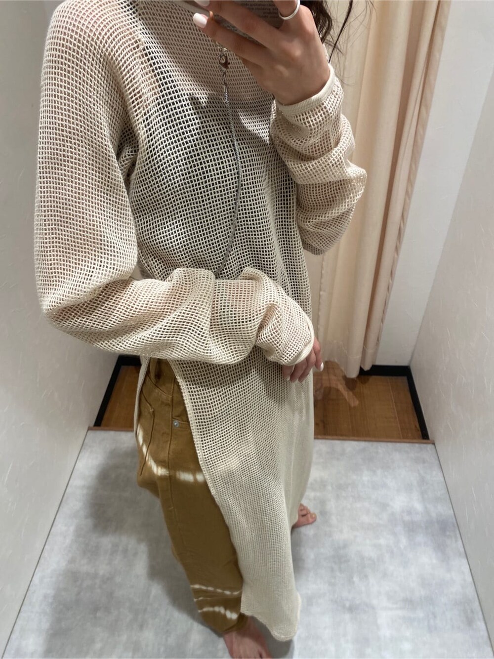 ホワイト系のワンピース、ブラウン系のデニムパンツを着用したレディースの春コーディネートの4枚目の写真