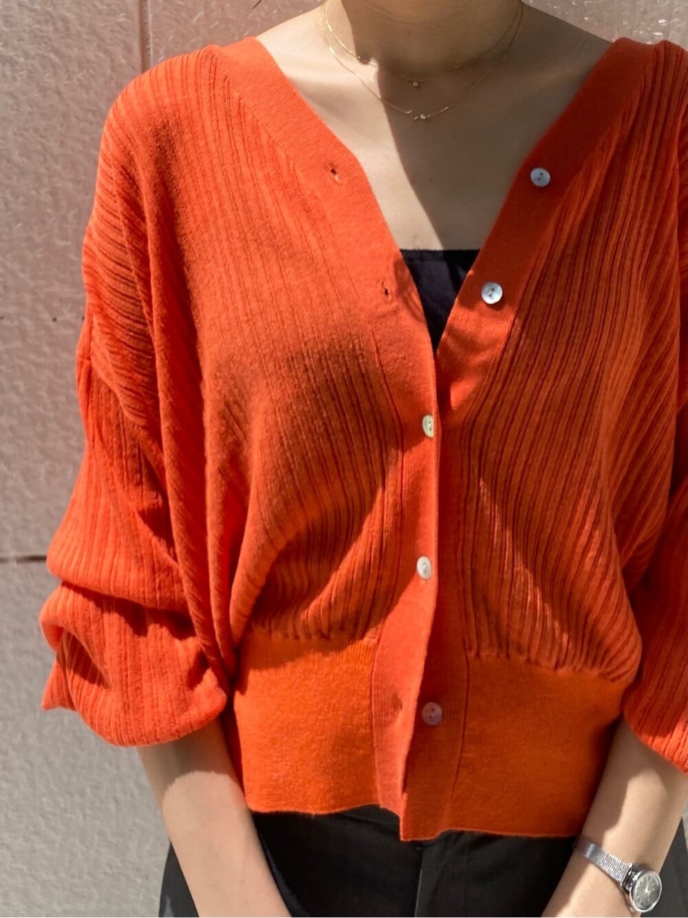 グレー系のその他パンツ、ブラック系のハンドバッグ、オレンジ系のカーディガン/ボレロを着用したレディースの春コーディネートの4枚目の写真
