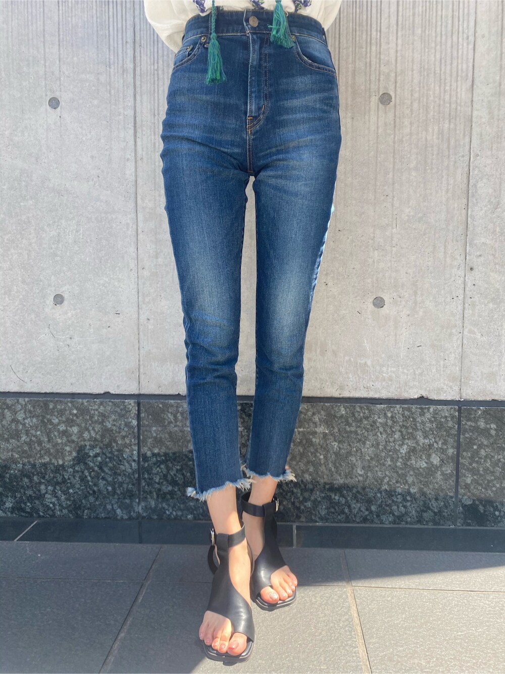 ブルー系のデニムパンツ、ホワイト系のシャツ/ブラウス、ブラック系のサンダルを着用したレディースの春コーディネートの5枚目の写真