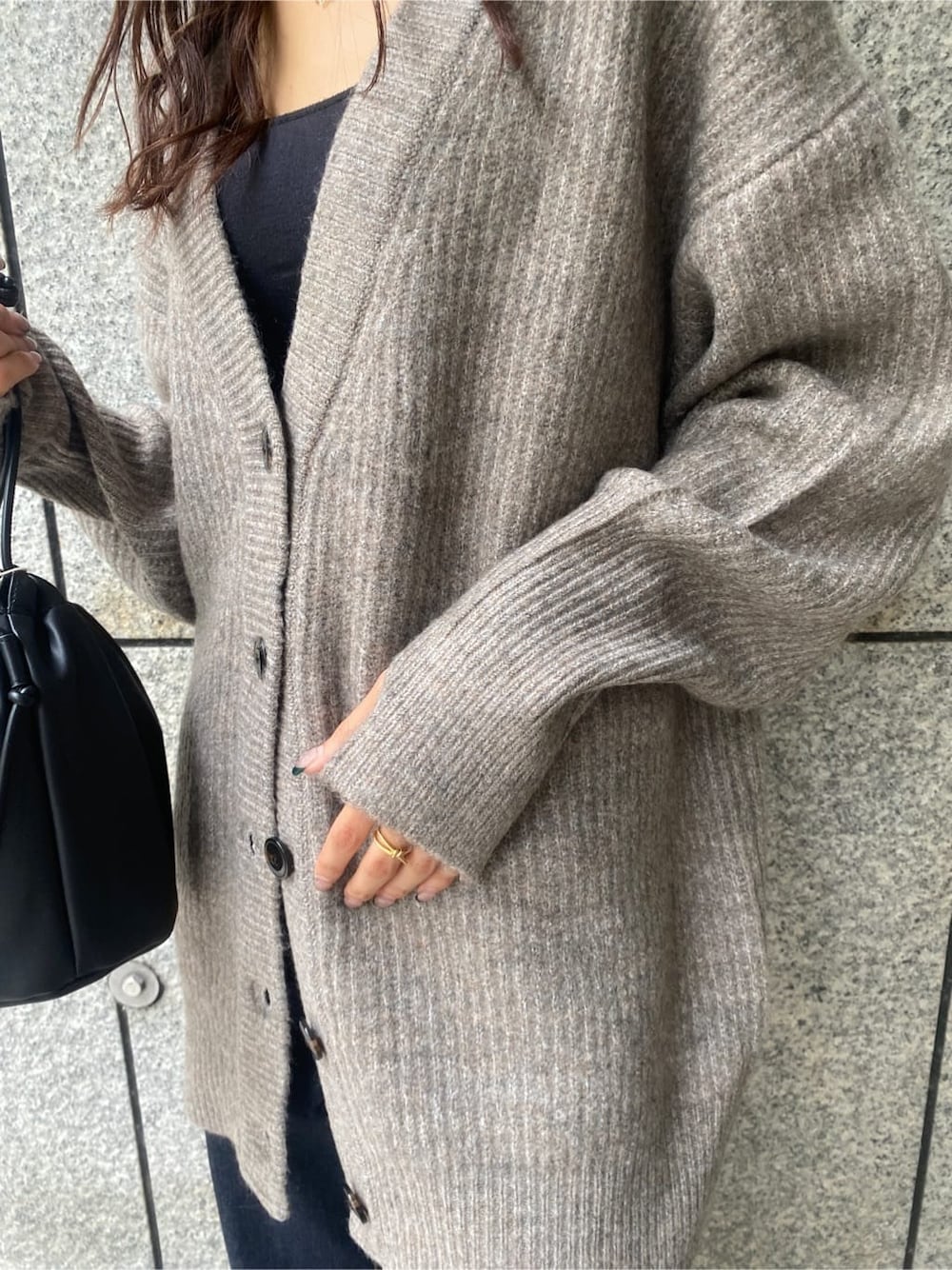 ゴールド系のパンプス、ブラック系のハンドバッグ、ブルー系のデニムパンツを着用したレディースの秋コーディネートの5枚目の写真