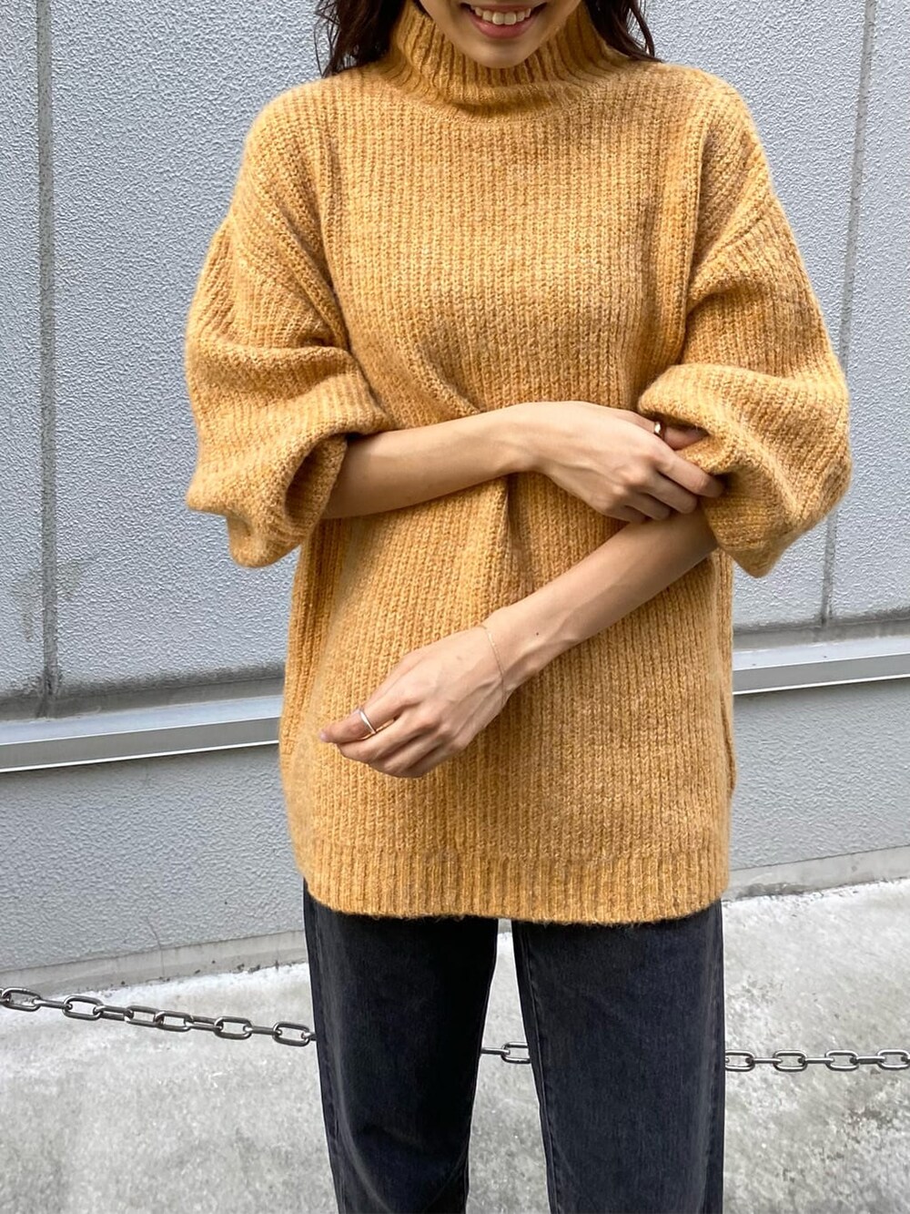 ブラック系のデニムパンツ、イエロー系のニット/セーターを着用したレディースの秋コーディネートの5枚目の写真