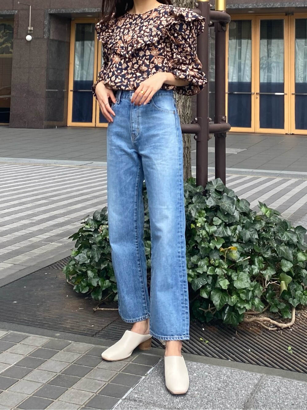 ブルー系のデニムパンツ、ブルー系のシャツ/ブラウス、ホワイト系のサンダルを着用したレディースの春コーディネートの2枚目の写真