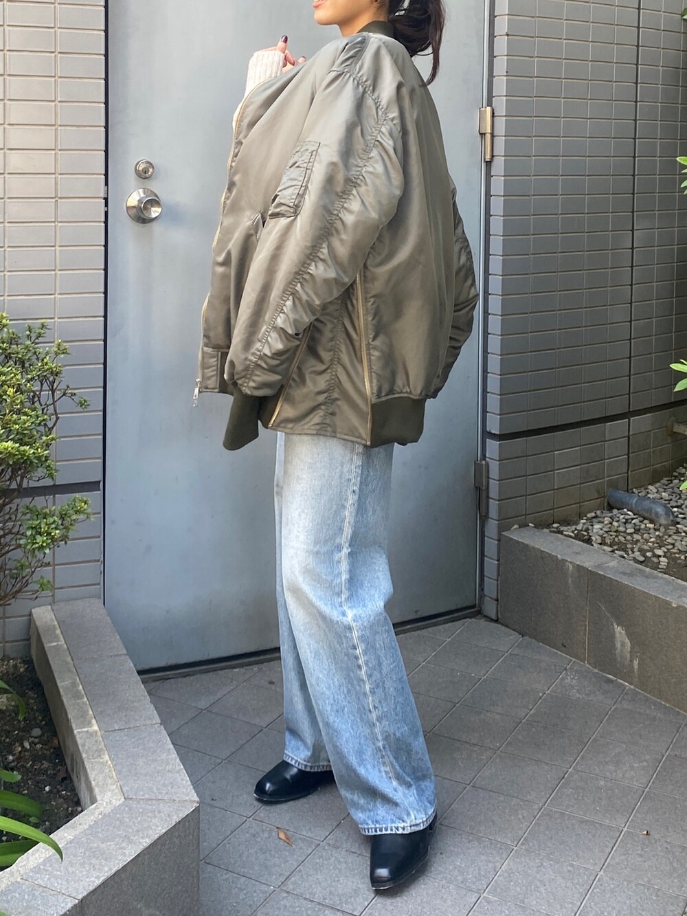 ホワイト系のニット/セーター、ブルー系のデニムパンツ、ブラック系のブーツを着用したレディースの秋コーディネートの3枚目の写真