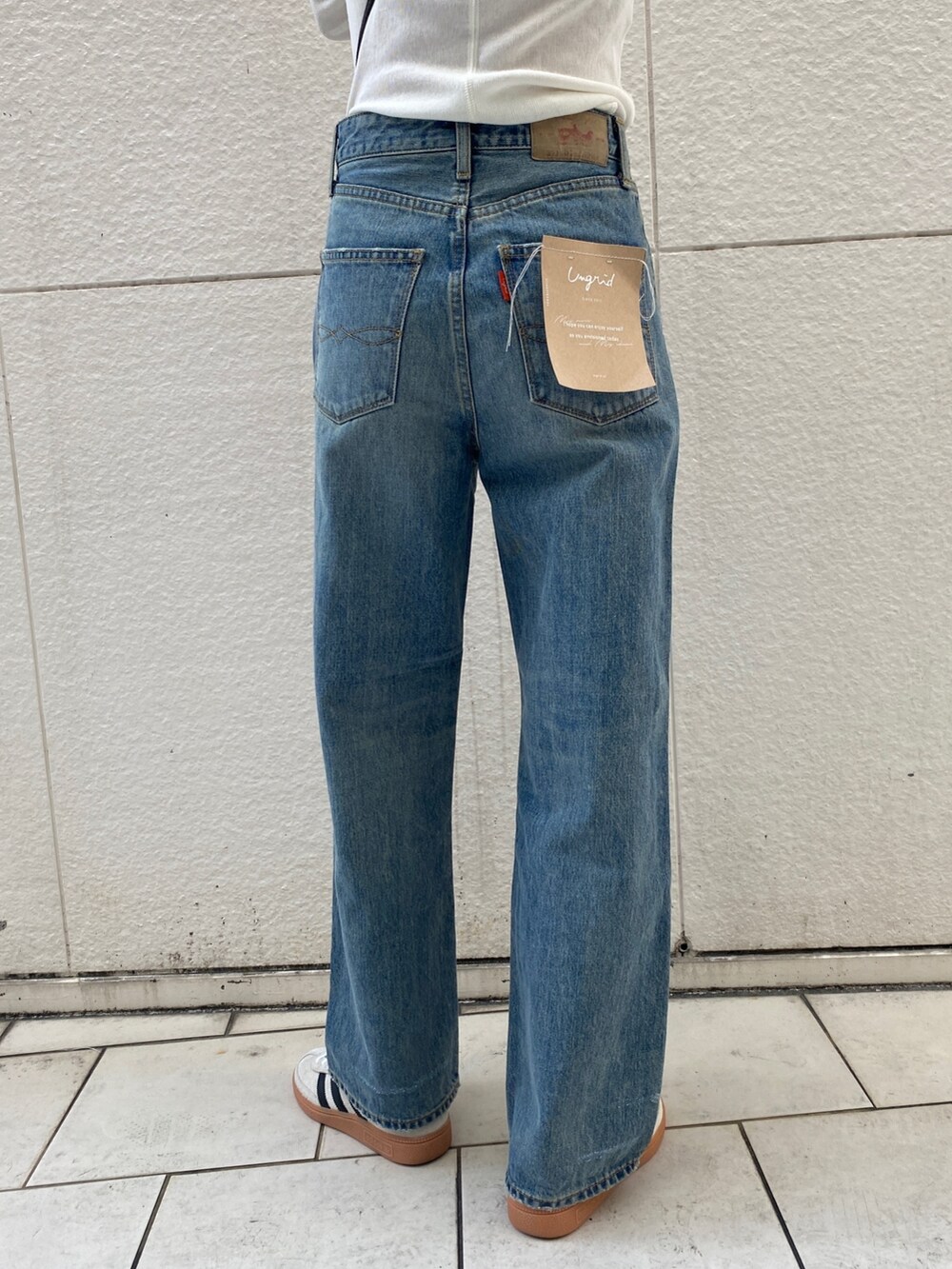 ベージュ系のその他アウター、ホワイト系のTシャツ/カットソー、ブルー系のデニムパンツを着用したレディースの冬コーディネートの6枚目の写真