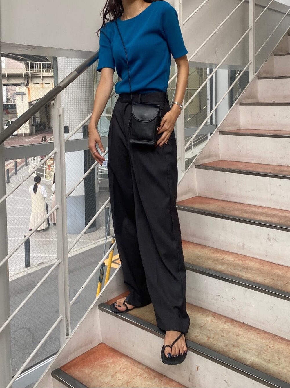 ブルー系のTシャツ/カットソー、グレー系のスラックスを着用したレディースの夏コーディネートの3枚目の写真