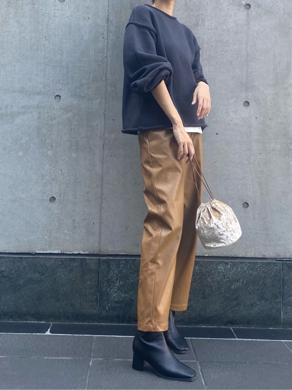 ブラウン系のその他パンツ、ブラック系のブーツ、ホワイト系のハンドバッグを着用したレディースの秋コーディネートの3枚目の写真