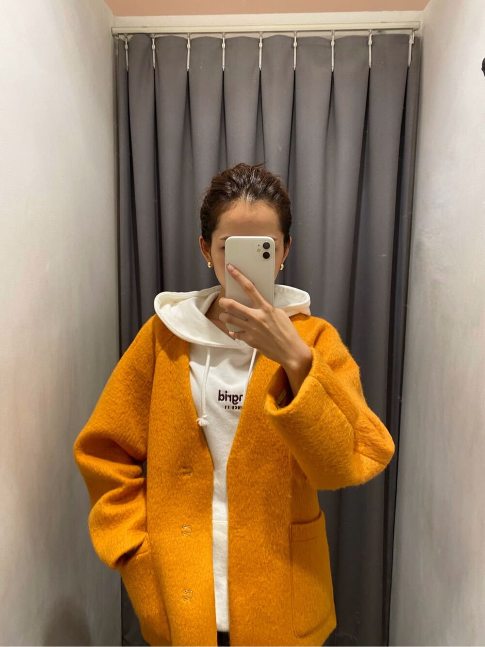 イエロー系のテーラードジャケット、ブラウン系のブーツ、ブルー系のデニムパンツを着用したレディースの秋コーディネートの2枚目の写真