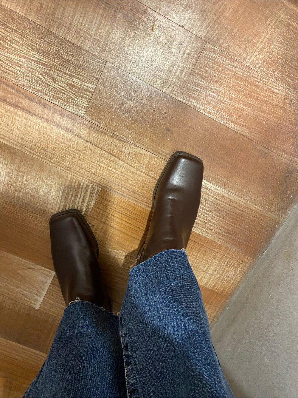 イエロー系のテーラードジャケット、ブラウン系のブーツ、ブルー系のデニムパンツを着用したレディースの秋コーディネートの5枚目の写真