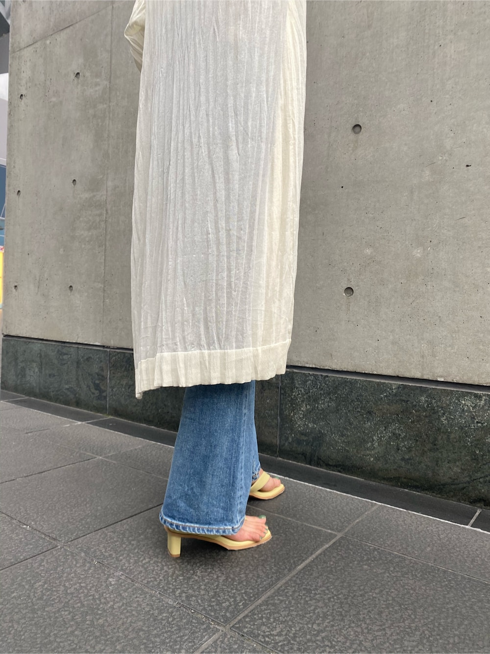 ホワイト系のタンクトップ、ブルー系のデニムパンツ、ホワイト系のカーディガン/ボレロを着用したレディースの春コーディネートの5枚目の写真