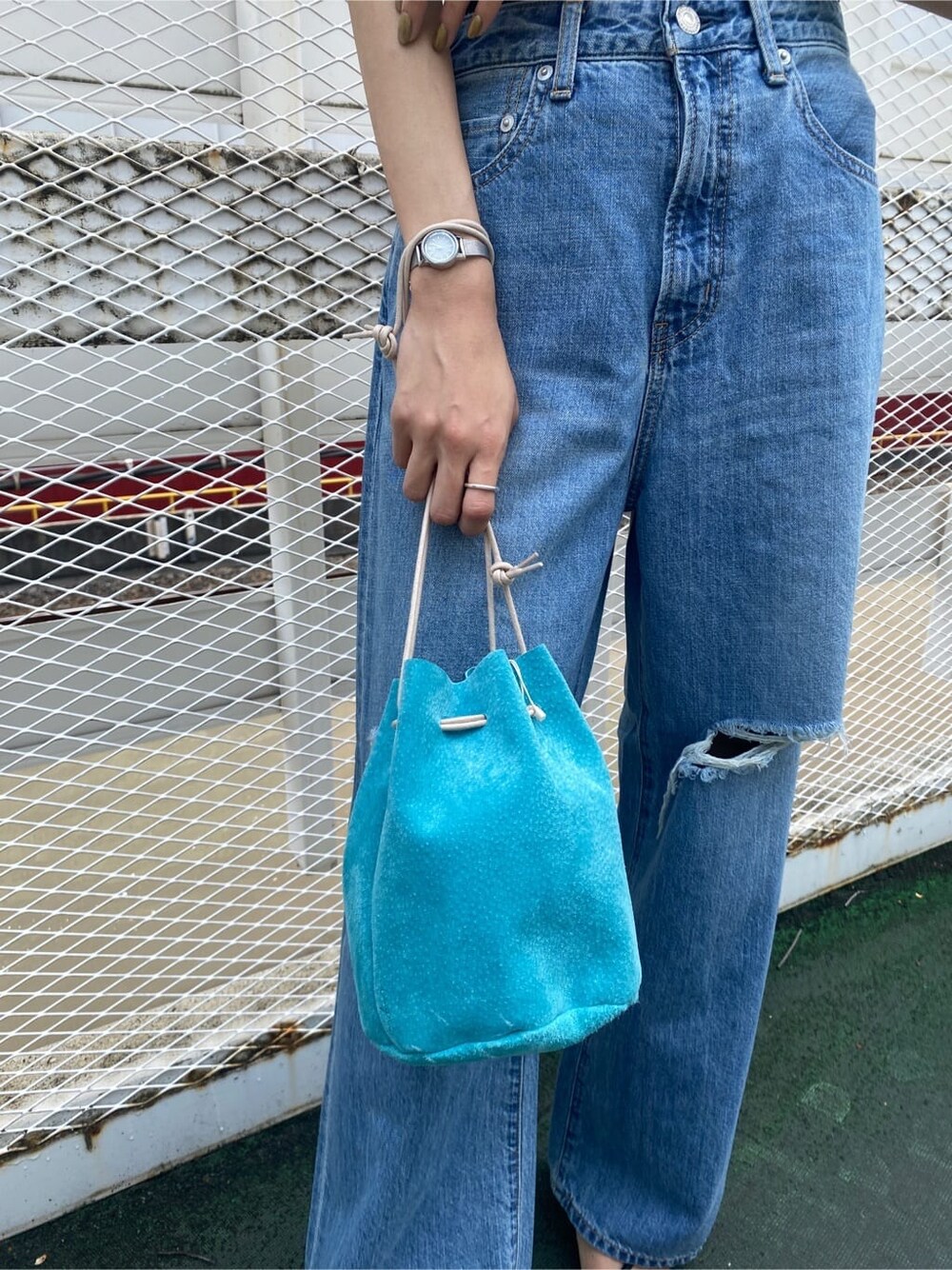 ブラック系のサンダル、ブルー系のハンドバッグ、ブラック系のタンクトップを着用したレディースの夏コーディネートの7枚目の写真