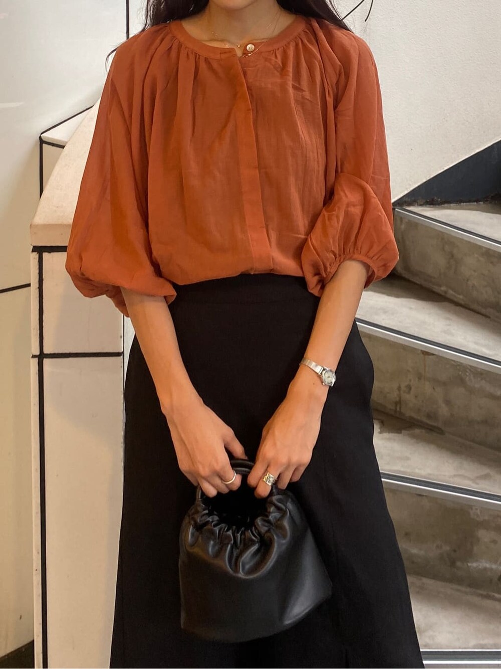 ブラック系のサンダル、オレンジ系のシャツ/ブラウス、ブラック系のスカートを着用したレディースの夏コーディネートの4枚目の写真