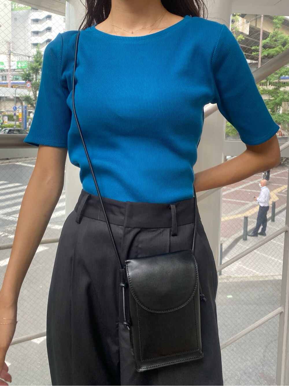 ブルー系のTシャツ/カットソー、グレー系のスラックスを着用したレディースの夏コーディネートの4枚目の写真