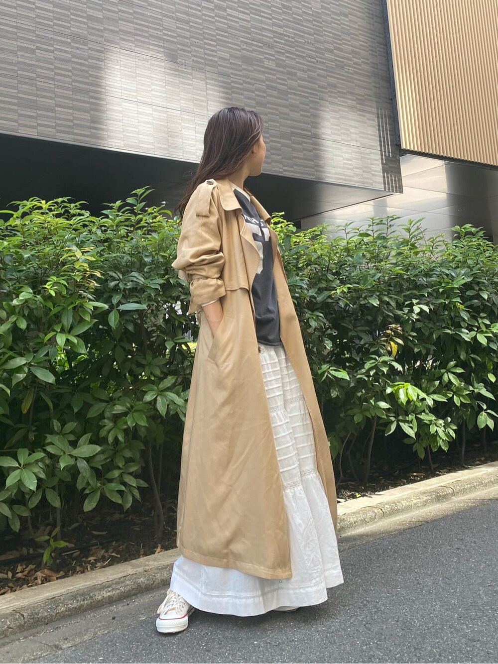 ベージュ系のトレンチコート、ホワイト系のスカート、グレー系のTシャツ/カットソーを着用したレディースの夏コーディネートの4枚目の写真