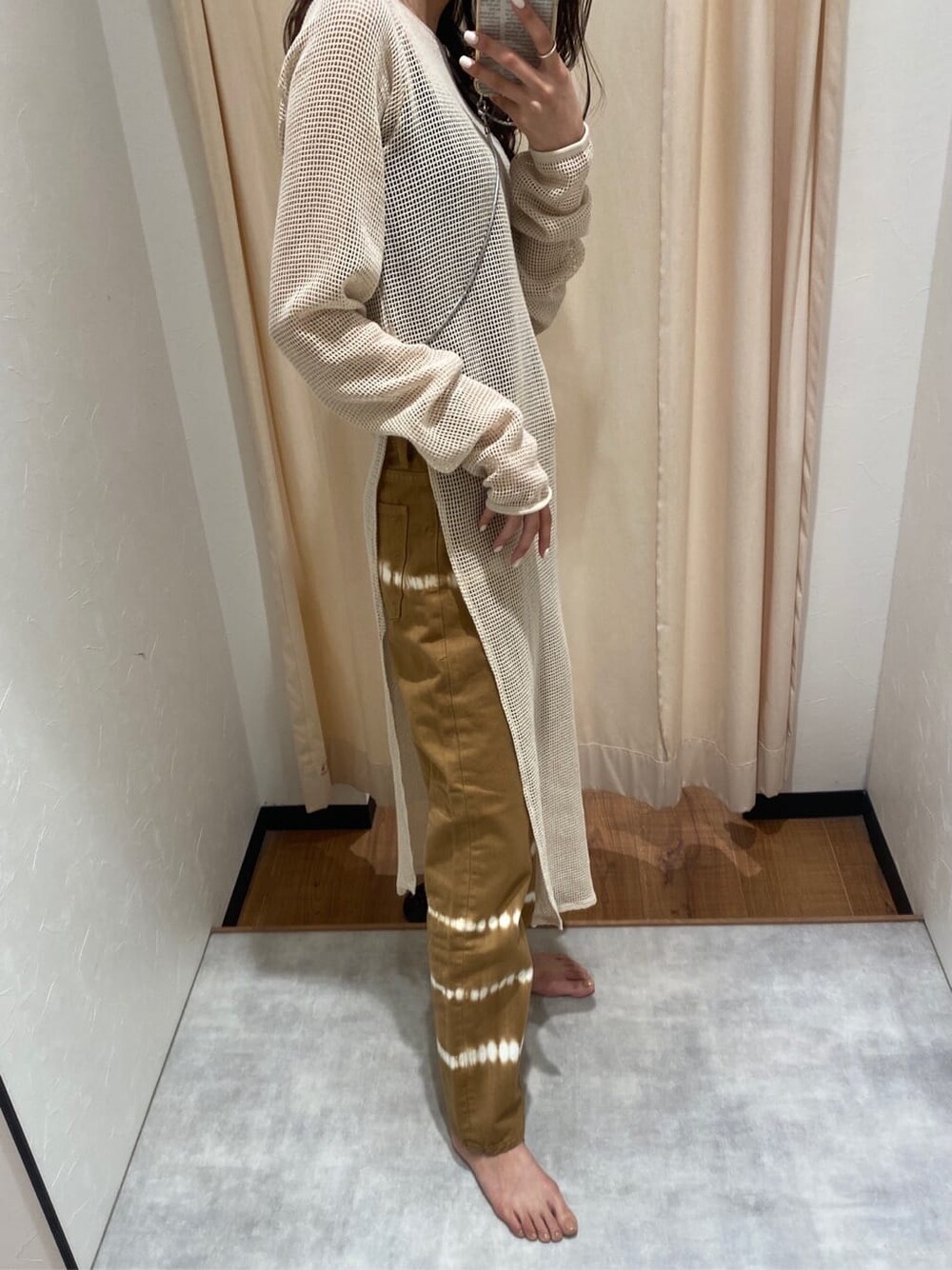 ホワイト系のワンピース、ブラウン系のデニムパンツを着用したレディースの春コーディネートの3枚目の写真