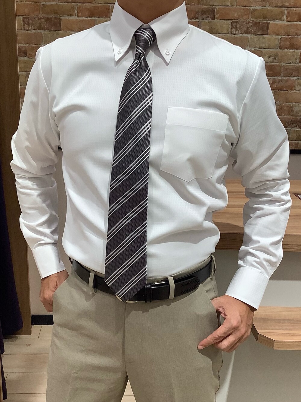 ホワイト系のビジネスシャツ、グレー系のネクタイを着用したメンズの秋コーディネートの2枚目の写真