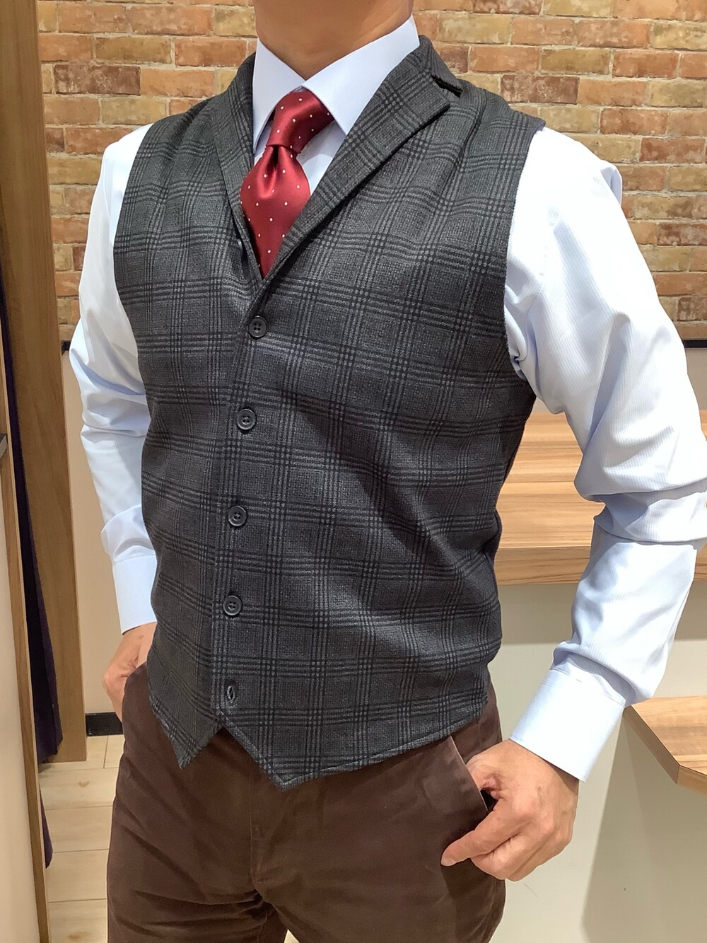 ブルー系のビジネスシャツ、レッド系のネクタイ、ブルー系のベストを着用したメンズの冬コーディネートの2枚目の写真