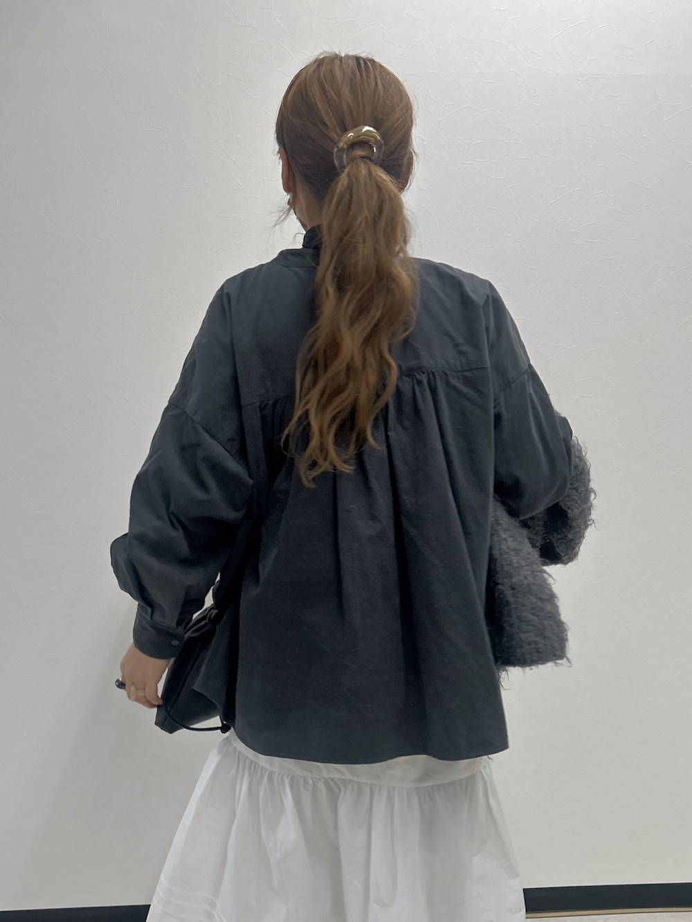 グレー系のシャツ/ブラウス、ホワイト系のワンピース、ブラック系のスニーカーを着用したレディースの冬コーディネートの3枚目の写真