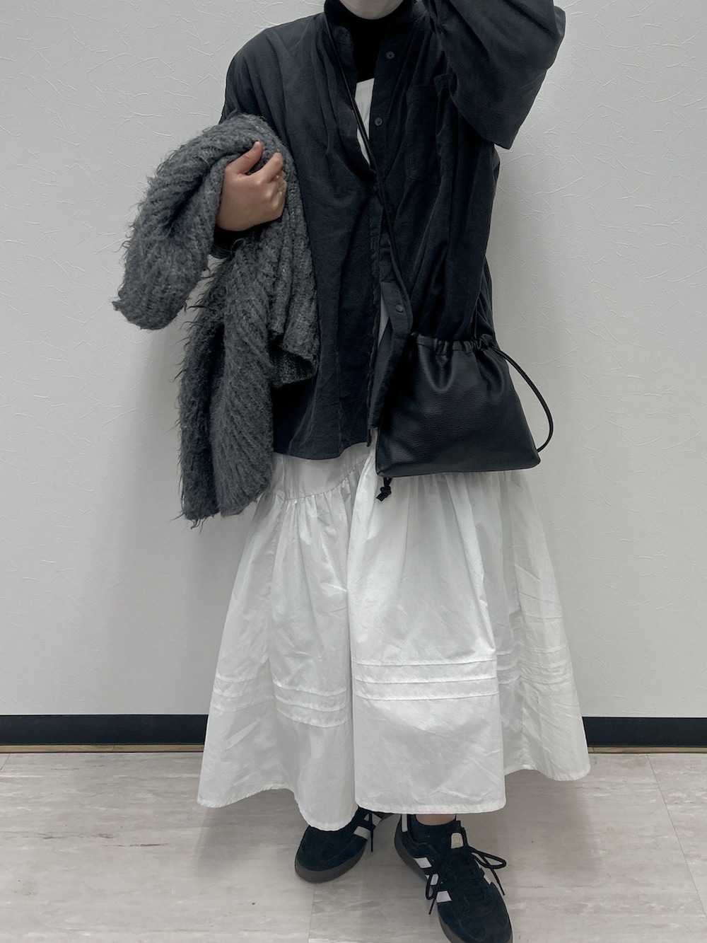 グレー系のシャツ/ブラウス、ホワイト系のワンピース、ブラック系のスニーカーを着用したレディースの冬コーディネートの4枚目の写真