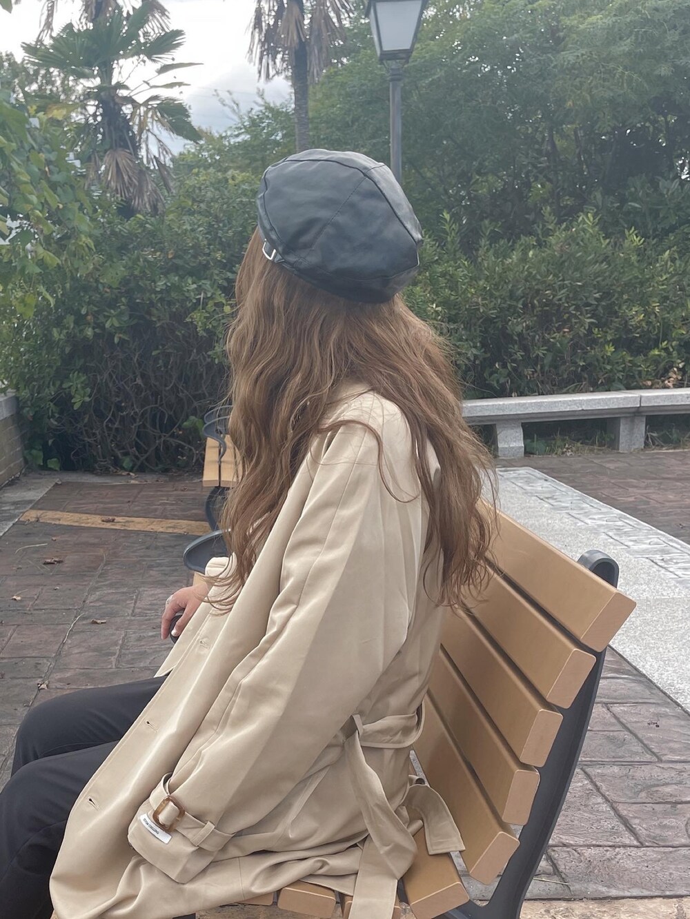 ベージュ系のトレンチコートを着用したレディースの秋コーディネートの2枚目の写真