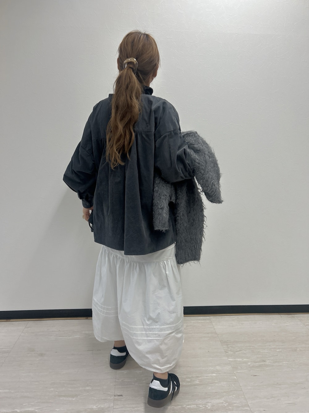 グレー系のシャツ/ブラウス、ホワイト系のワンピース、ブラック系のスニーカーを着用したレディースの冬コーディネートの2枚目の写真