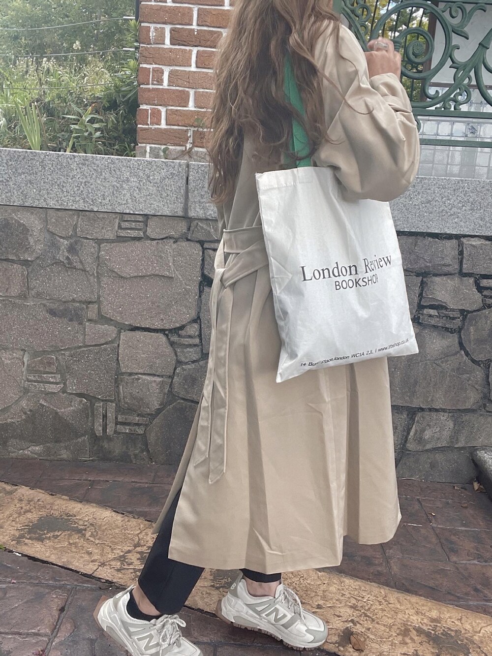 ベージュ系のトレンチコートを着用したレディースの秋コーディネートの4枚目の写真