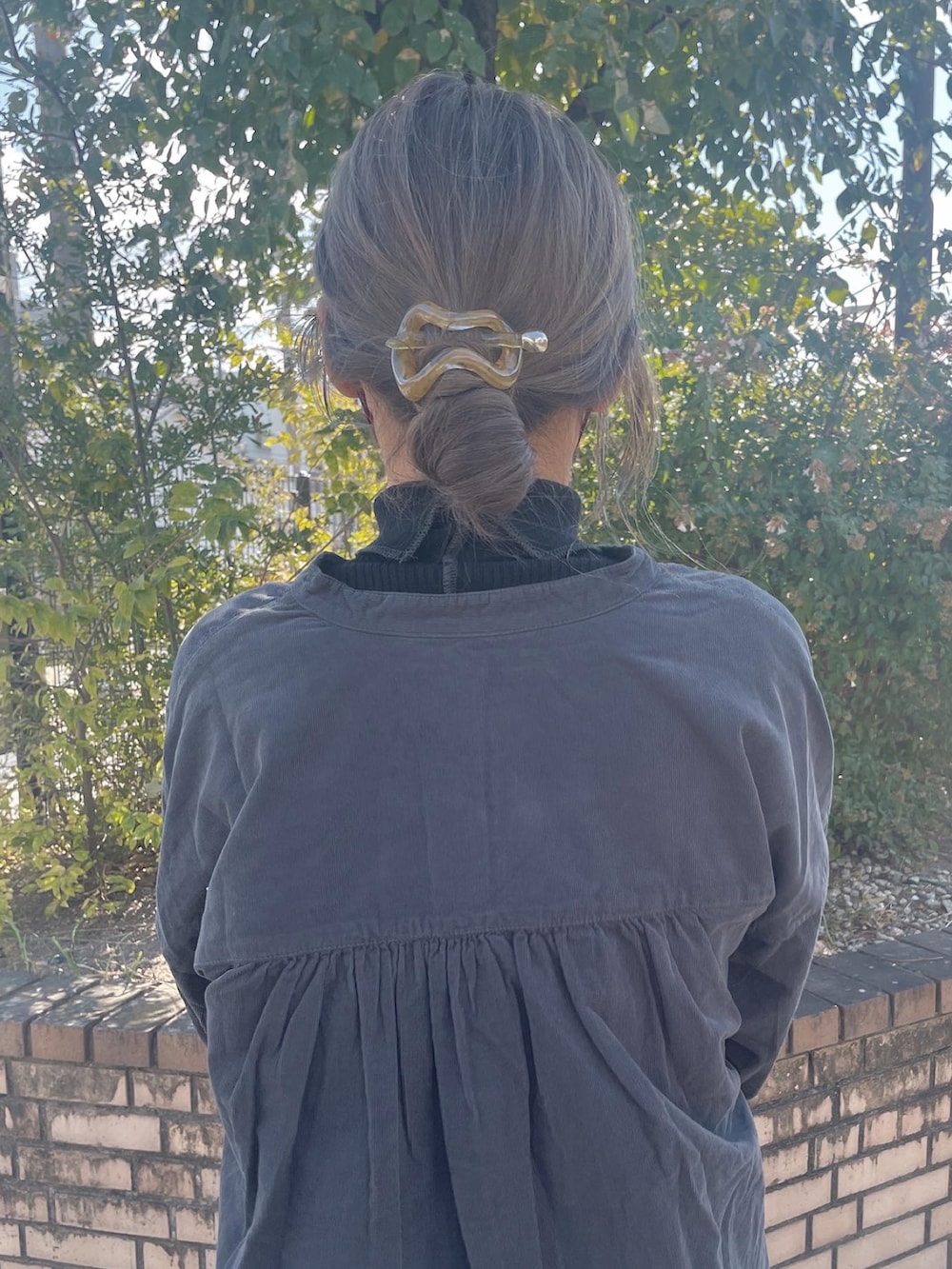 グレー系のシャツ/ブラウス、ホワイト系のワンピース、ブラック系のニット/セーターを着用したレディースの秋コーディネートの2枚目の写真