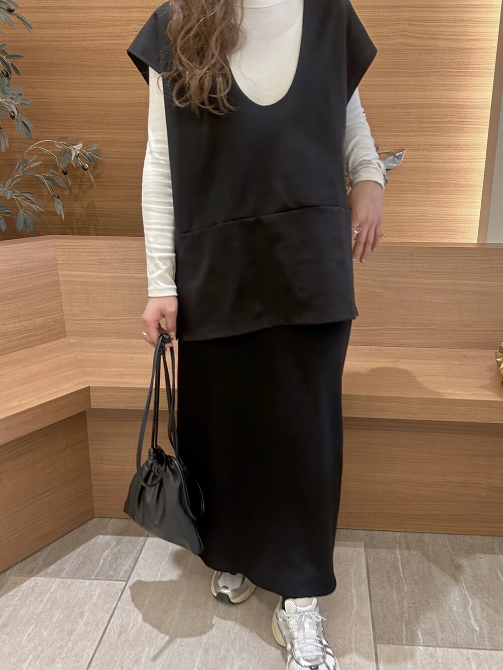 ブラック系のベストを着用したレディースの春コーディネートの2枚目の写真