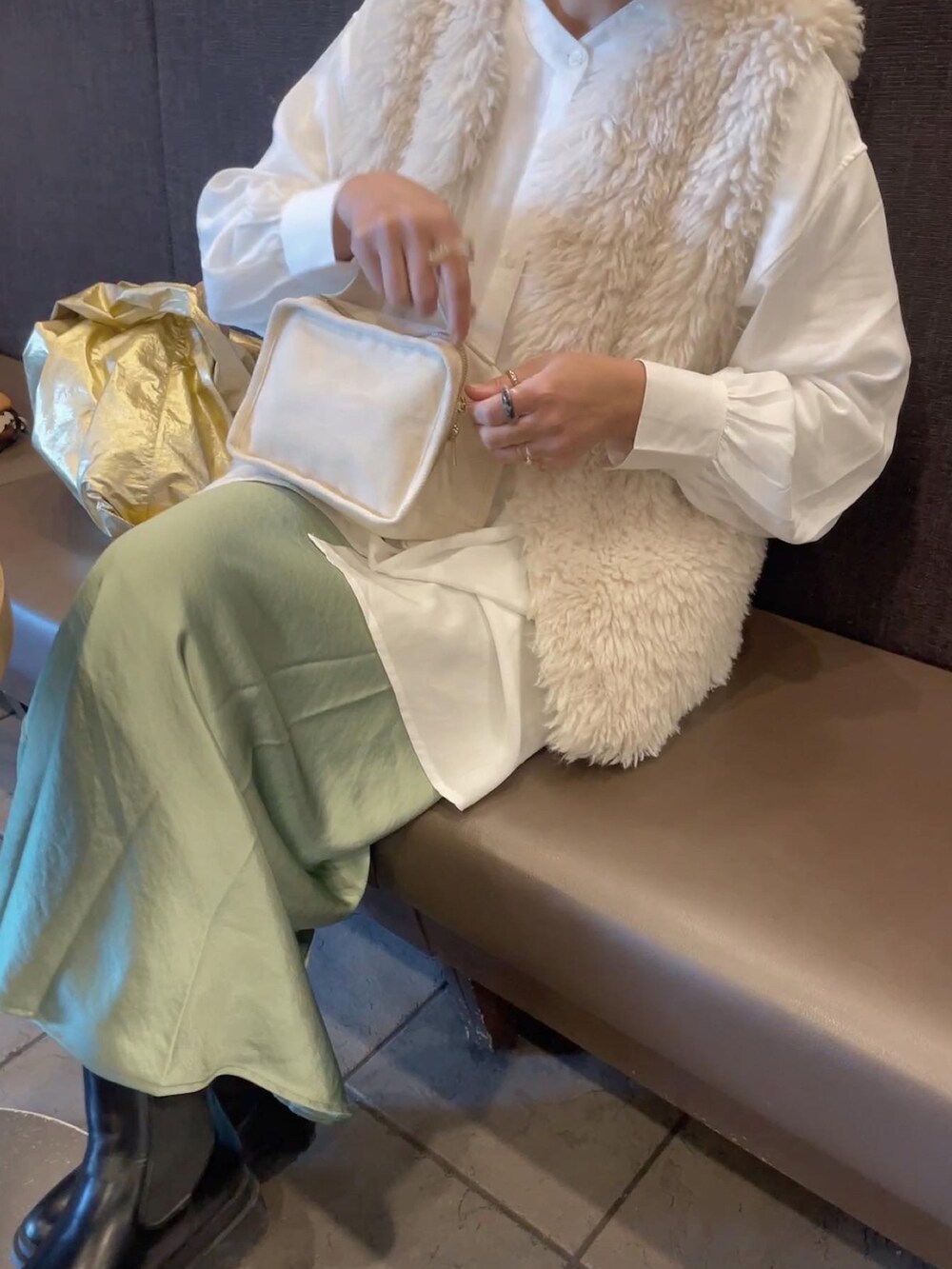 ホワイト系のベスト、ホワイト系のシャツ/ブラウス、グリーン系のスカートを着用したレディースの冬コーディネートの2枚目の写真