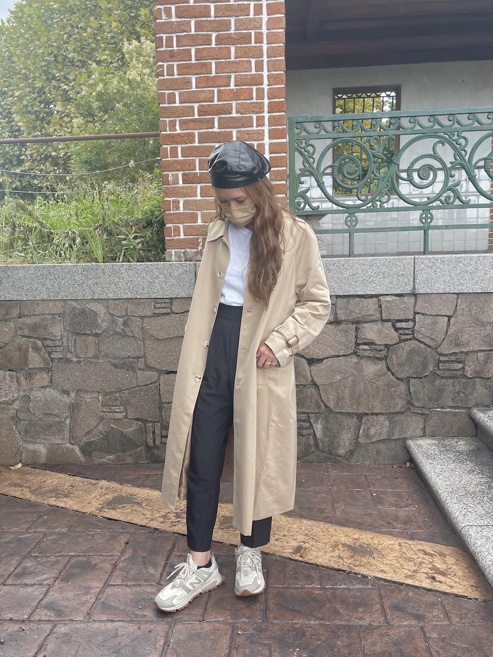ベージュ系のトレンチコートを着用したレディースの秋コーディネートの3枚目の写真