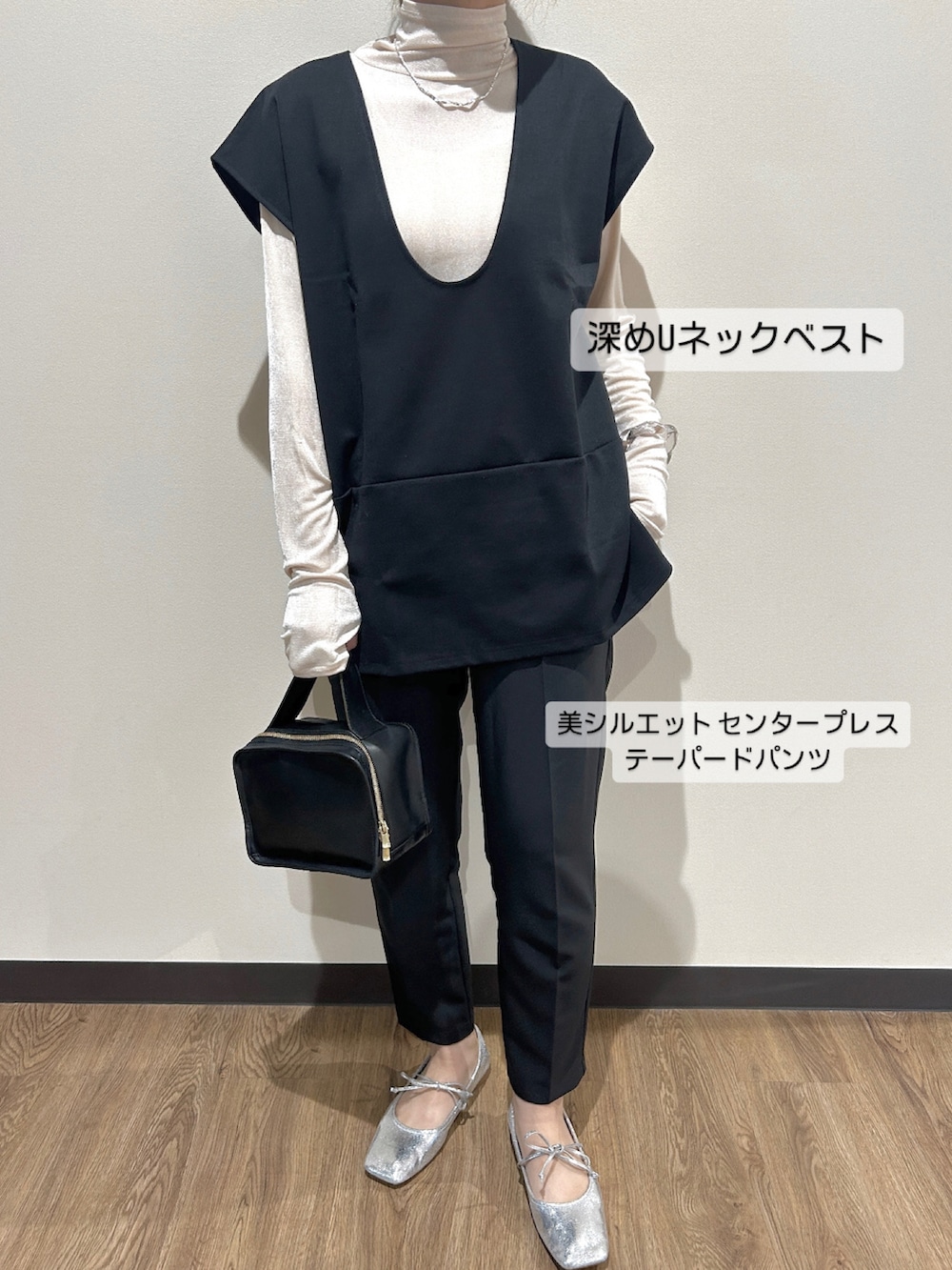 ブラック系のベスト、ブラック系のパンツを着用したレディースの春コーディネートの2枚目の写真