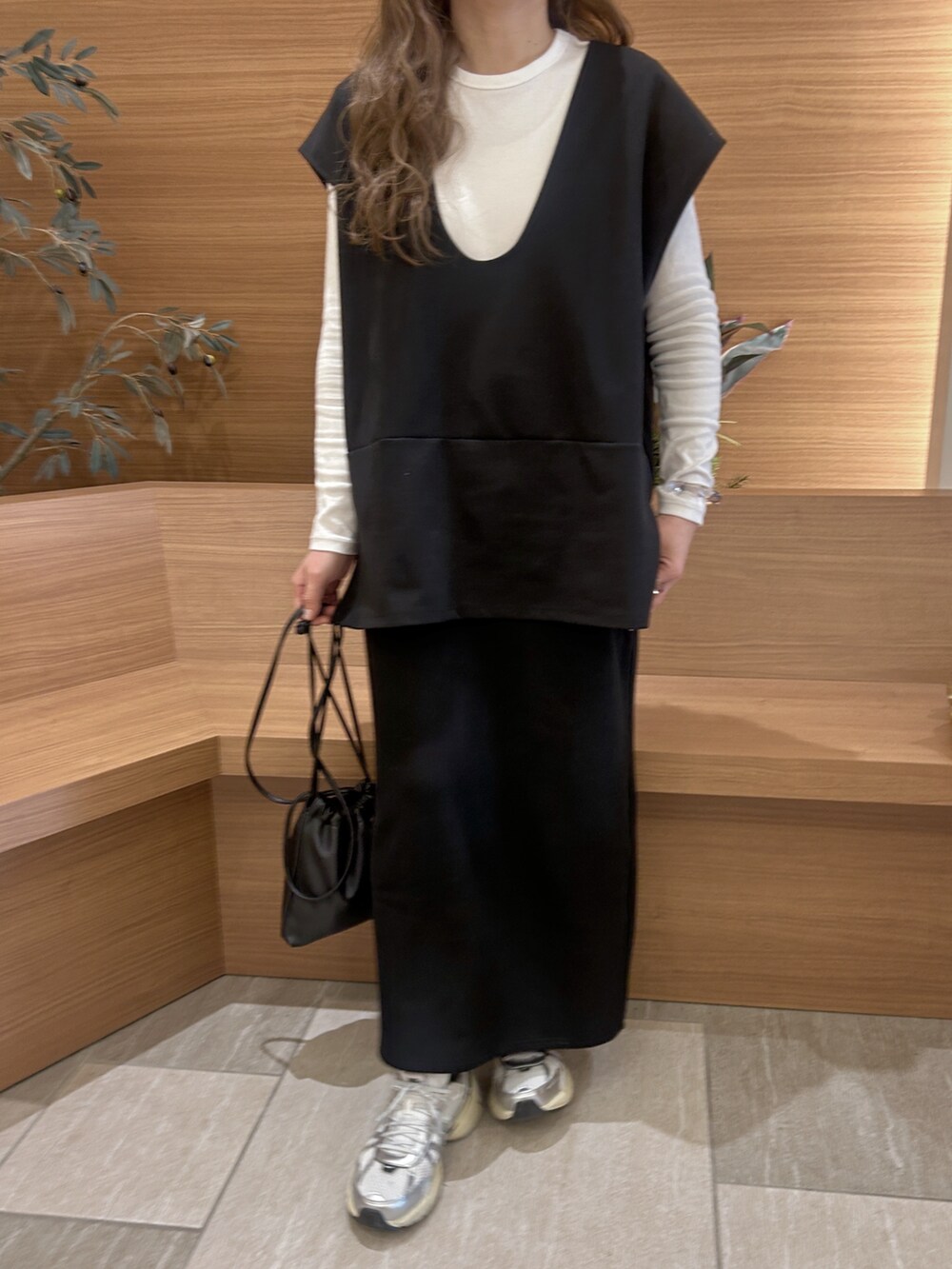 ブラック系のベストを着用したレディースの春コーディネートの5枚目の写真