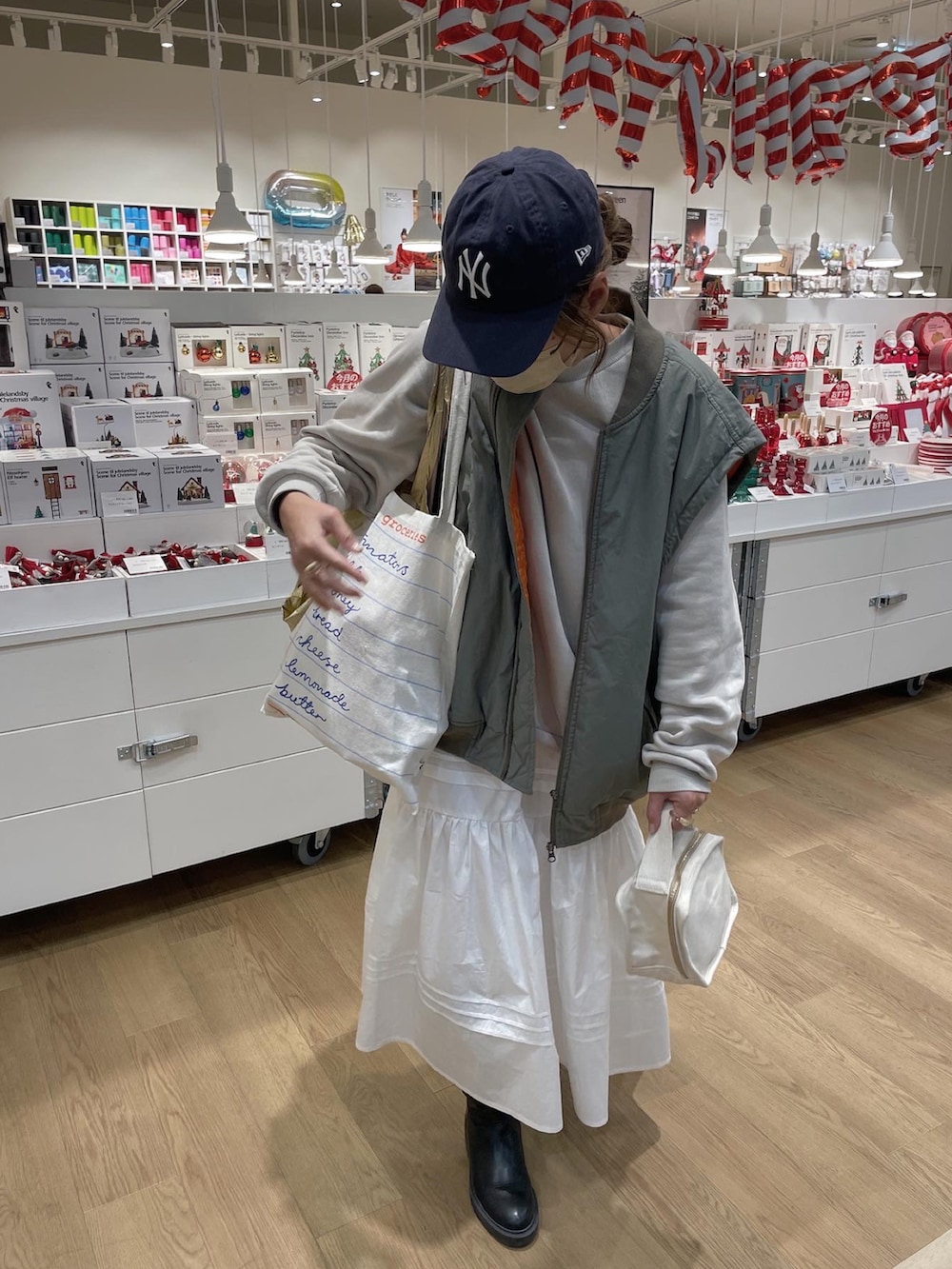 ベージュ系のスウェット、ブラック系のスカート、ブルー系のキャップを着用したレディースの秋コーディネートの4枚目の写真