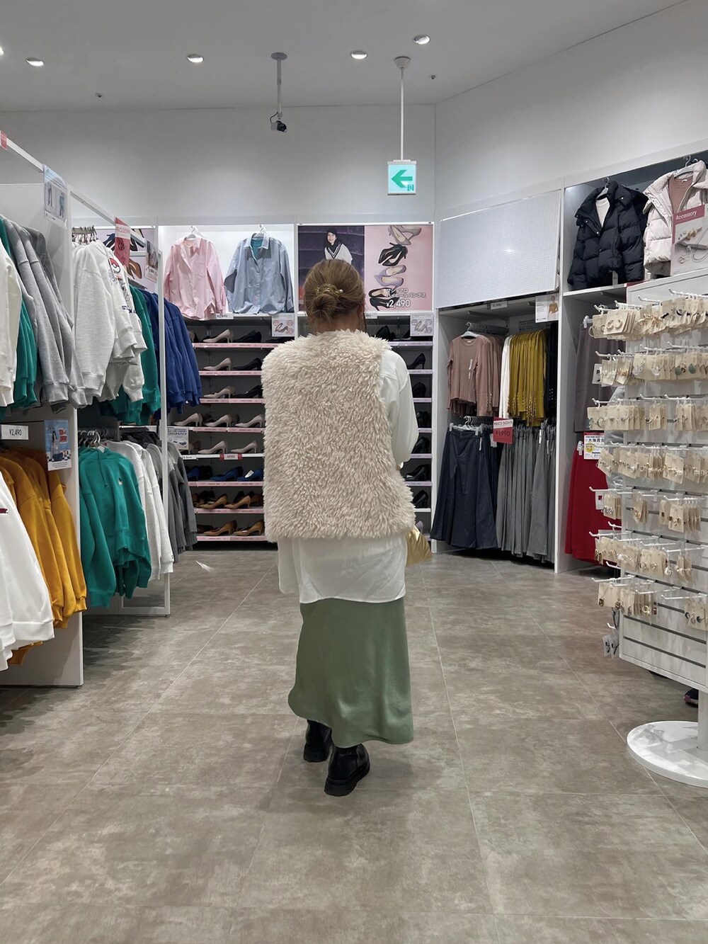 ホワイト系のベスト、ホワイト系のシャツ/ブラウス、グリーン系のスカートを着用したレディースの冬コーディネートの3枚目の写真