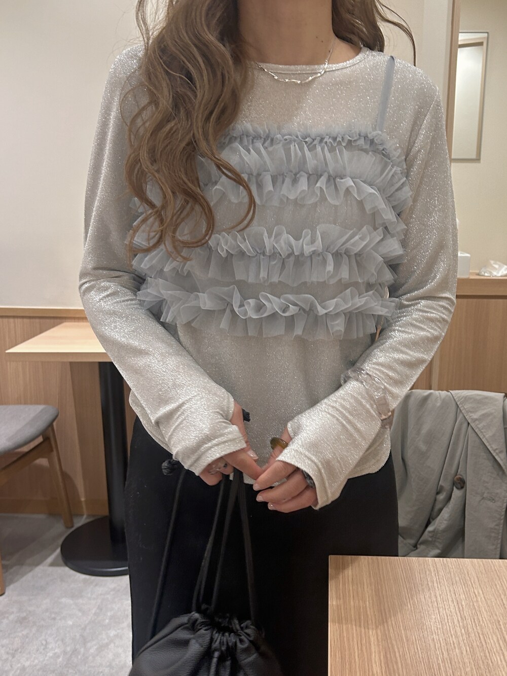 シルバー系のTシャツ/カットソー、ブラック系のスカート、ブラック系のスニーカーを着用したレディースの冬コーディネートの3枚目の写真