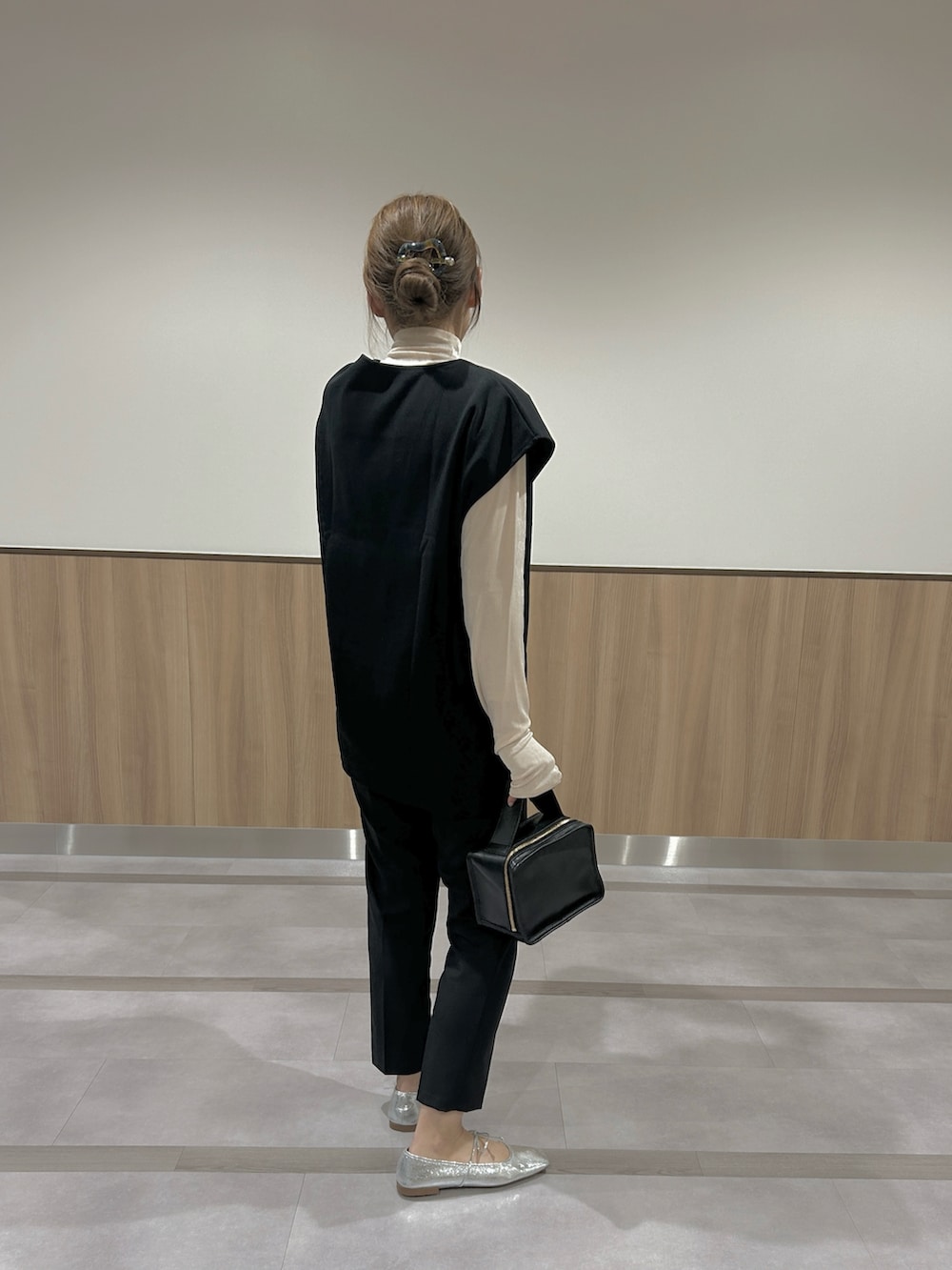 ブラック系のベスト、ブラック系のパンツを着用したレディースの春コーディネートの4枚目の写真