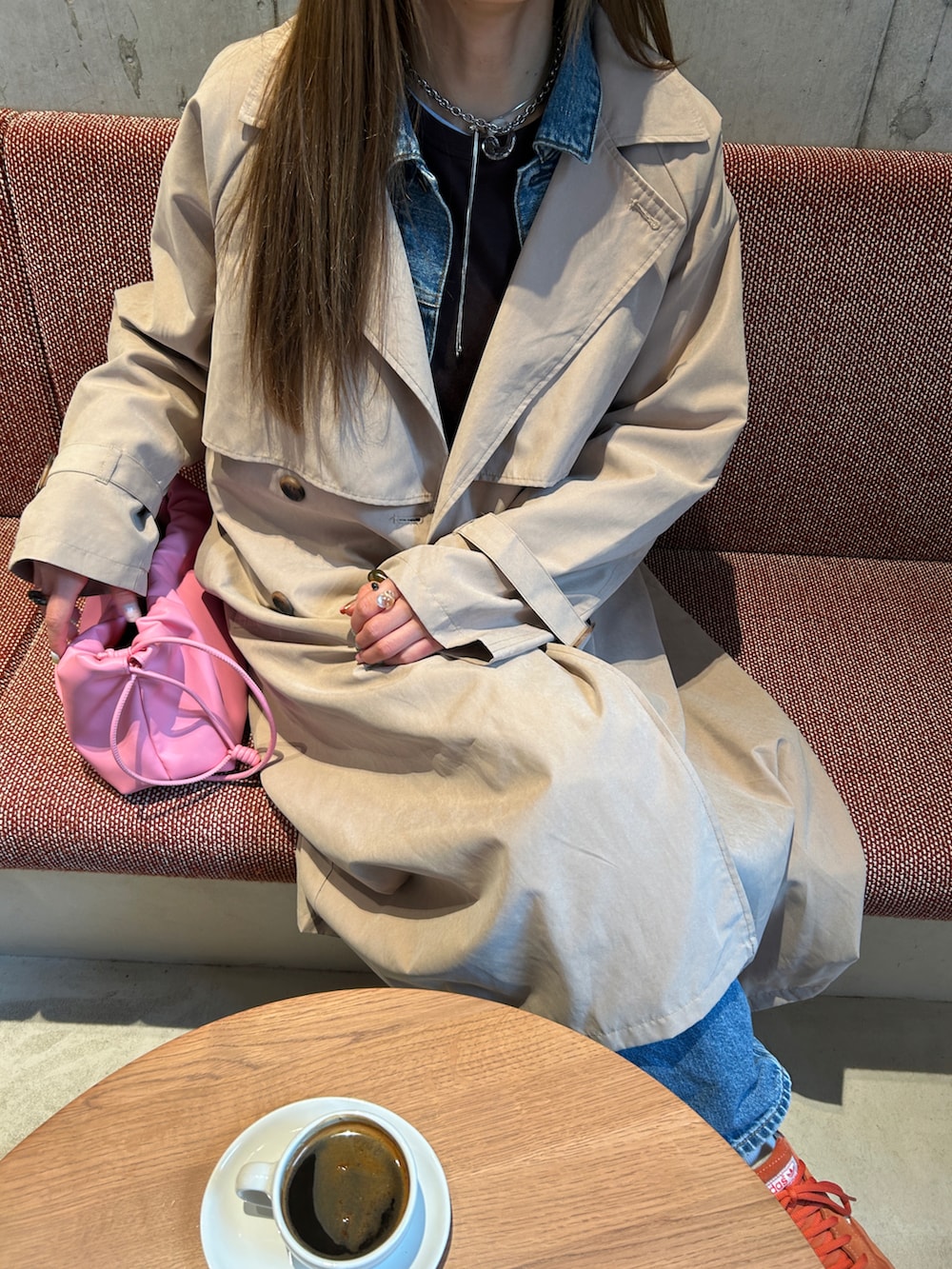 ベージュ系のトレンチコートを着用したレディースの春コーディネートの2枚目の写真