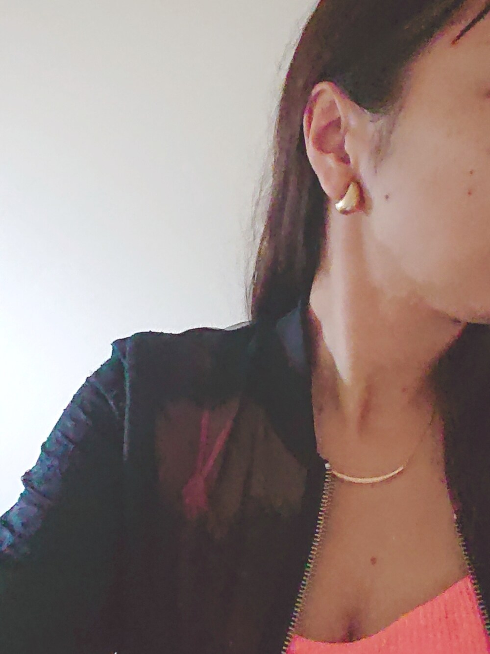 ブルー系のデニムパンツ、オレンジ系のキャミソール、ブラック系のブルゾンを着用したレディースの秋コーディネートの3枚目の写真