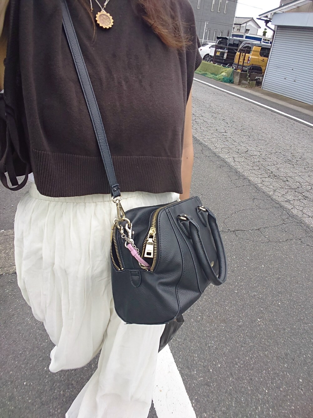 ブラウン系のベスト、ホワイト系のパンツ、ブラウン系のサンダルを着用したレディースの夏コーディネートの4枚目の写真