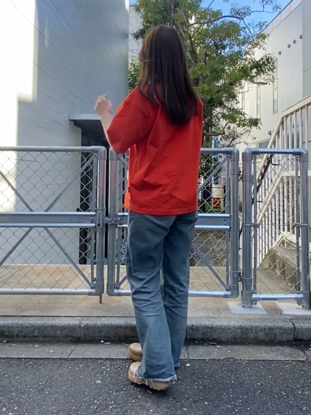 レッド系のTシャツ/カットソー、ベージュ系のサンダルを着用したレディースの春コーディネートの2枚目の写真