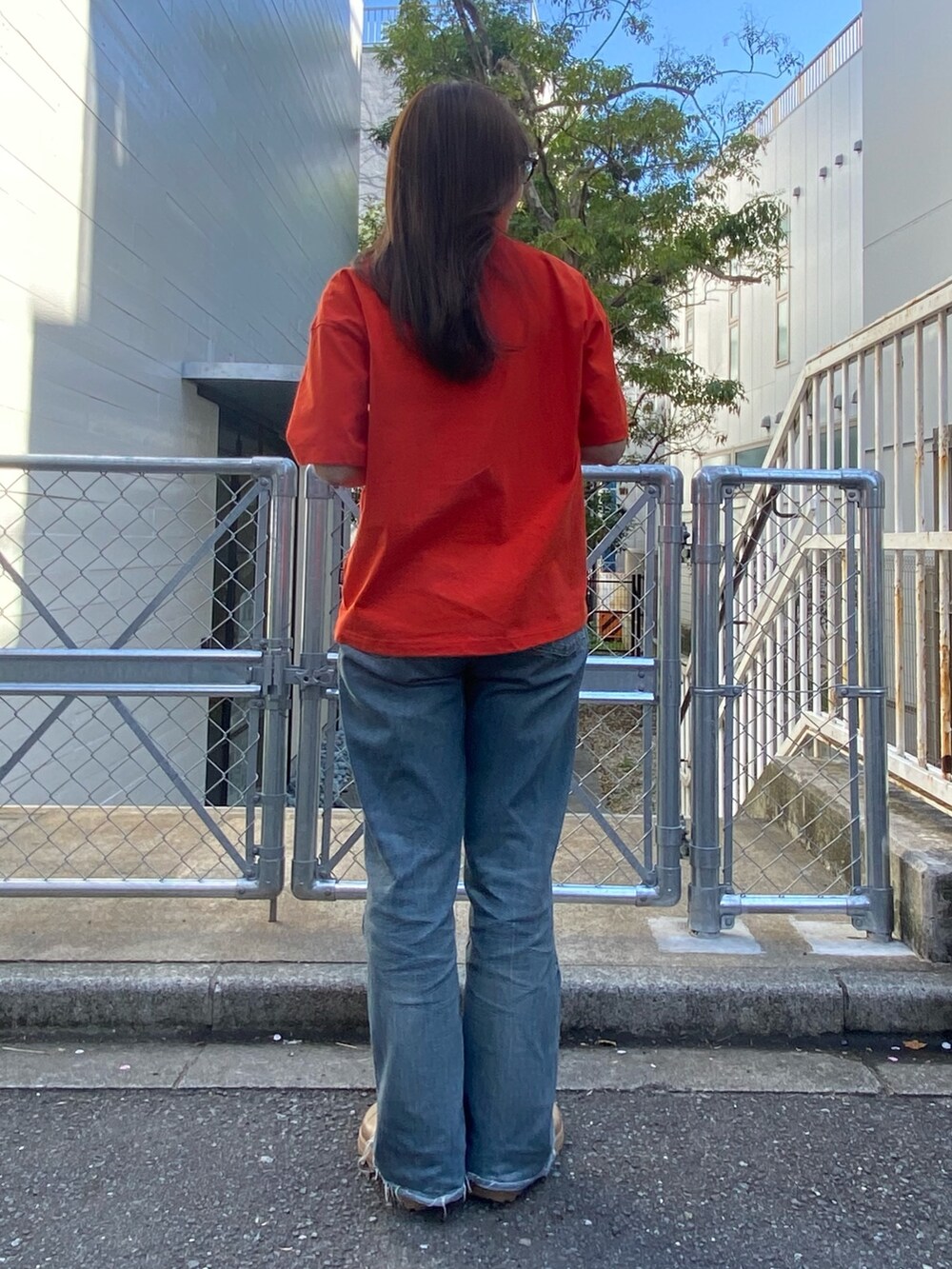 レッド系のTシャツ/カットソー、ベージュ系のサンダルを着用したレディースの春コーディネートの3枚目の写真