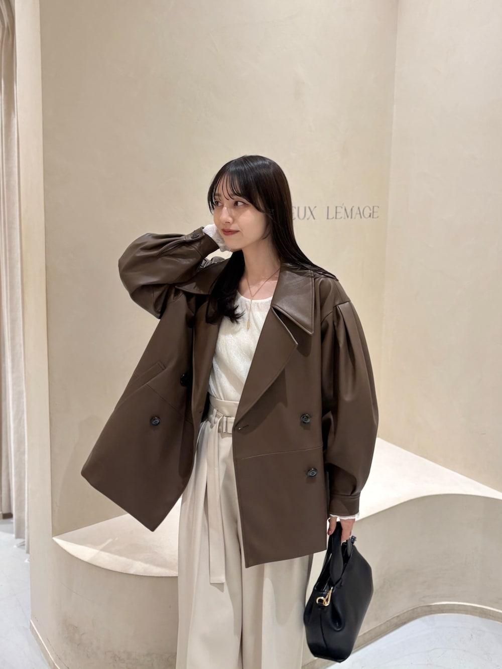 ブラック系のパンプス、ブラウン系のその他アウター、ホワイト系のその他パンツを着用したレディースの春コーディネートの2枚目の写真