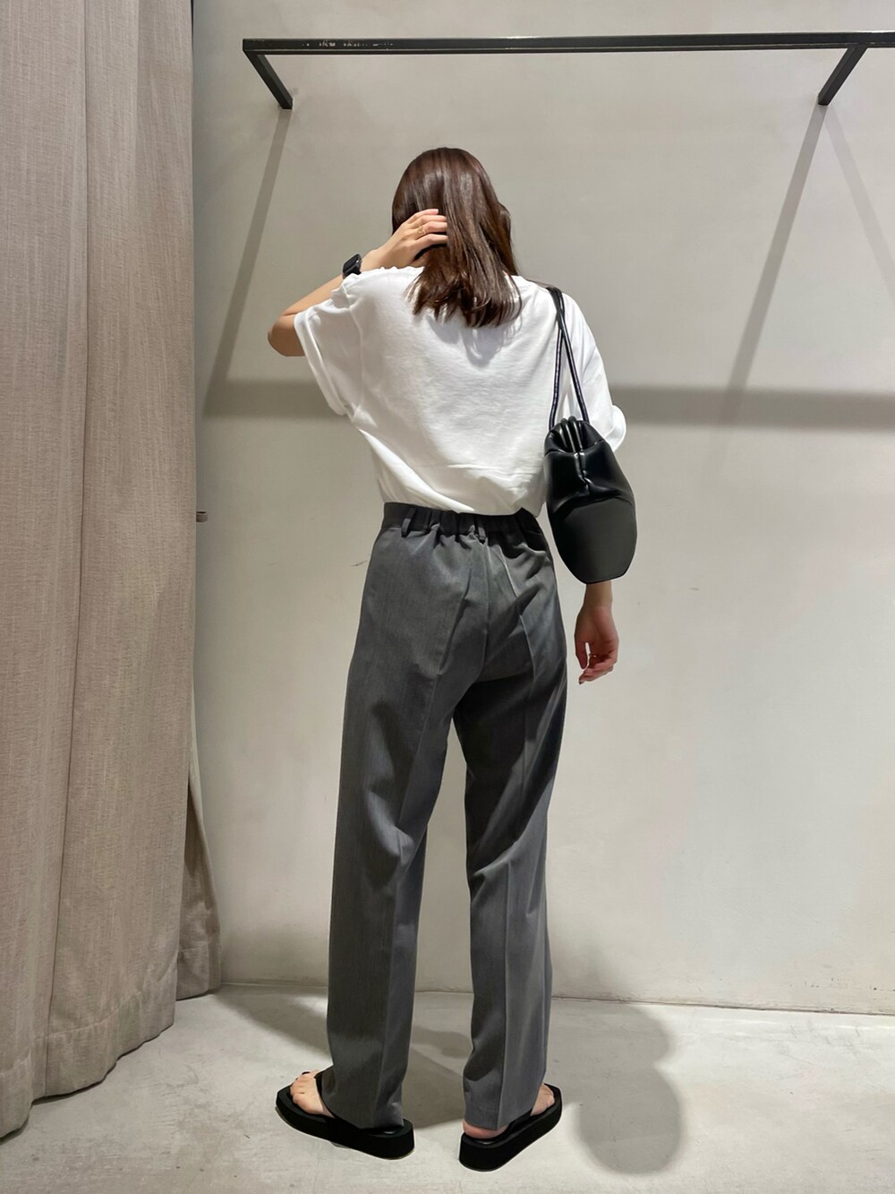 ホワイト系のTシャツ/カットソー、グレー系のスラックス、ブラック系のサンダルを着用したレディースの夏コーディネートの4枚目の写真