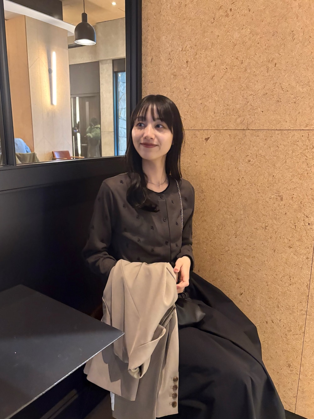 ブラック系のスカート、ブラック系のパンプス、グレー系のカーディガン/ボレロを着用したレディースの春コーディネートの4枚目の写真