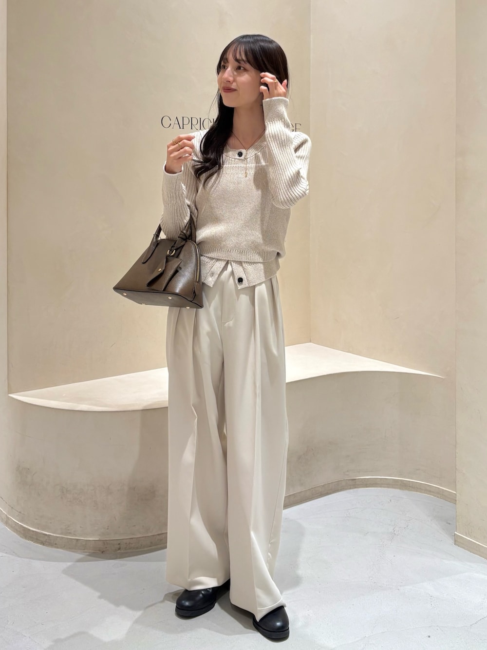 ホワイト系のその他パンツ、ブラウン系のショルダーバッグ、ブラック系のブーツを着用したレディースの冬コーディネートの5枚目の写真