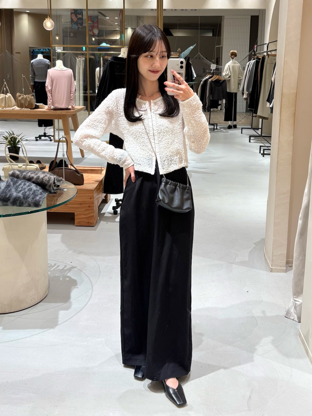 ブラック系のショルダーバッグ、ブラック系のスカート、ホワイト系のシャツ/ブラウスを着用したレディースの春コーディネートの3枚目の写真