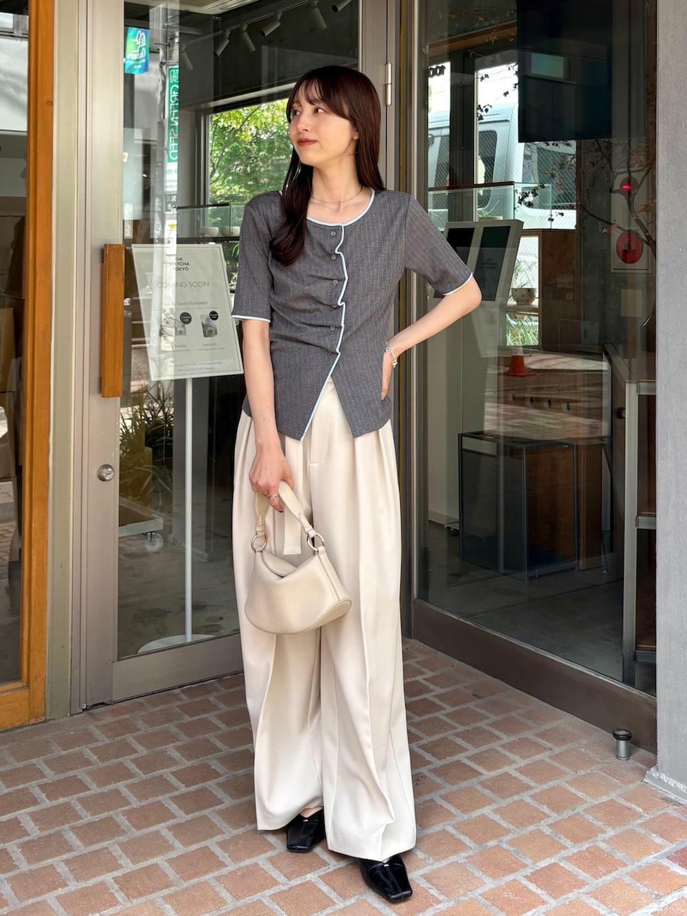 ホワイト系のその他パンツ、グレー系のTシャツ/カットソー、ホワイト系のショルダーバッグを着用したレディースの夏コーディネートの3枚目の写真