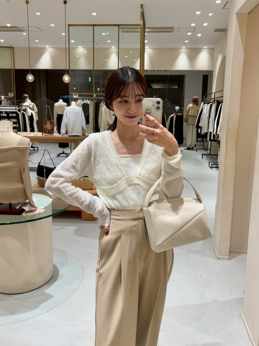 ベージュ系のその他パンツ、ホワイト系のハンドバッグ、ホワイト系のニット/セーターを着用したレディースの春コーディネートの2枚目の写真