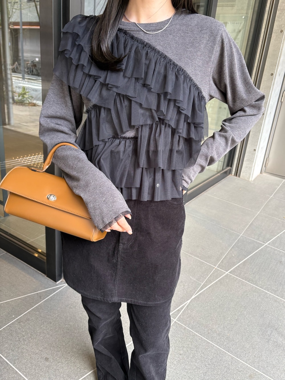 ブラック系のスカート、ブラック系のその他パンツ、グレー系のTシャツ/カットソーを着用したレディースの冬コーディネートの3枚目の写真