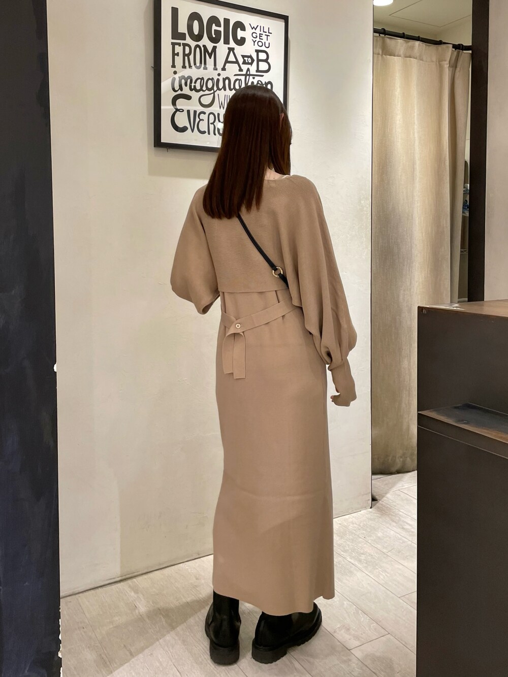 ベージュ系のワンピース、ブラック系のショルダーバッグ、ブラック系のブーツを着用したレディースの秋コーディネートの4枚目の写真