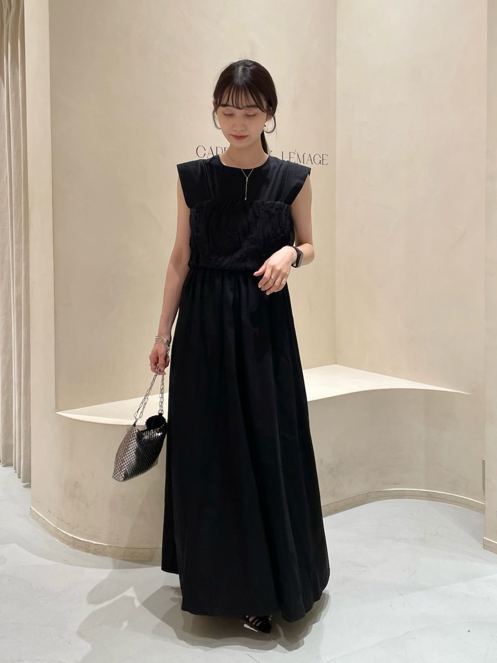 シルバー系のショルダーバッグ、ブラック系のワンピース/ドレス、ブラック系のトップスを着用したレディースの夏コーディネートの2枚目の写真